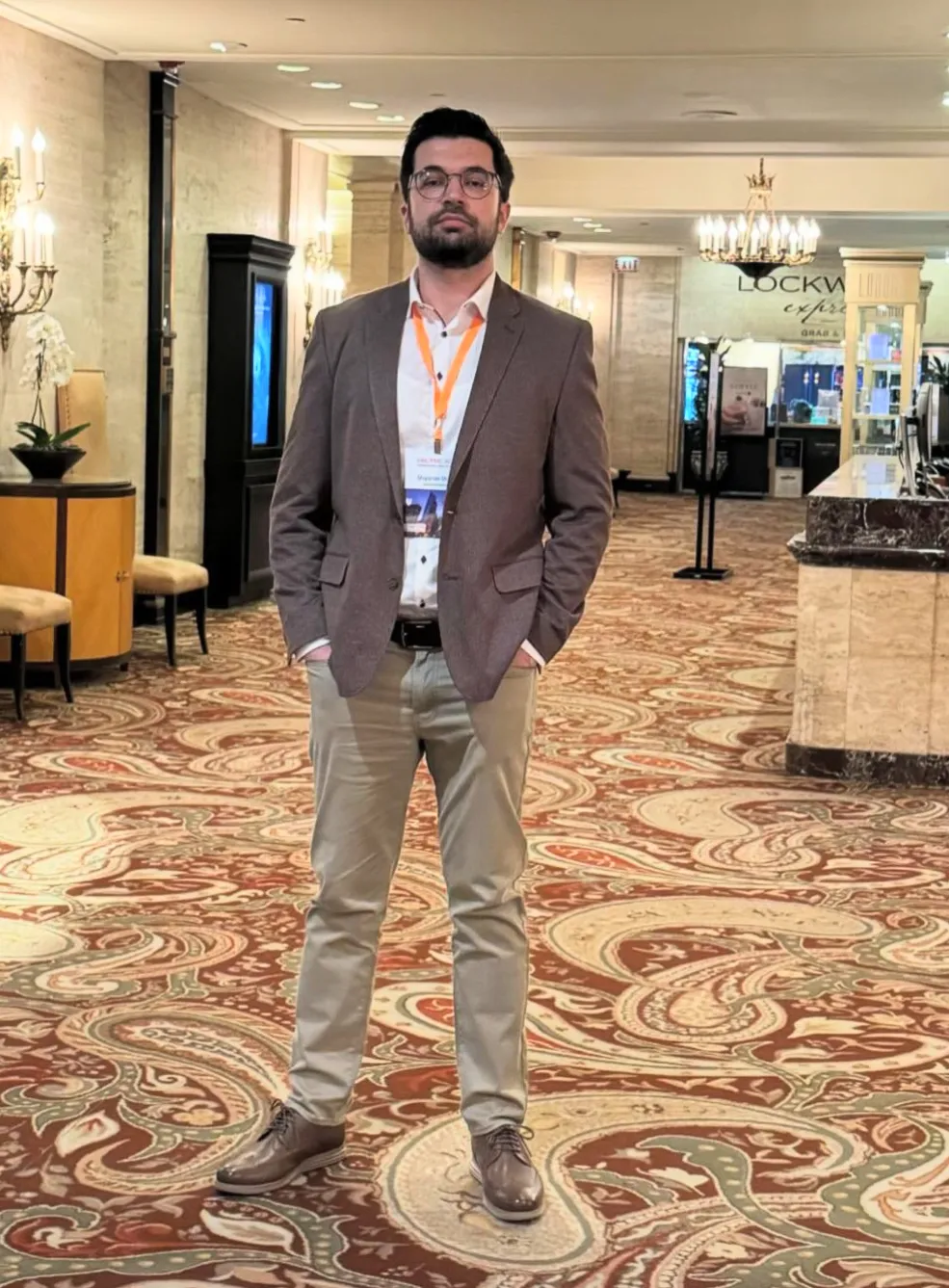 Shqipron Shala standing in conference lobby.